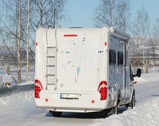 Wohnmobil auf einer verschneiten Landstraße