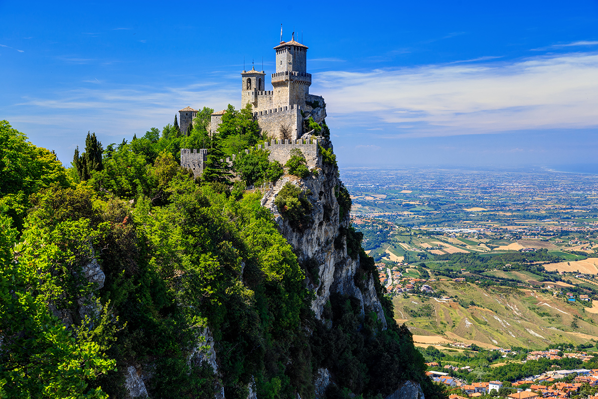 Blick aus der Ferne auf die Altstadt und Festung San Marinos sowie auf die adriatische Küste. 