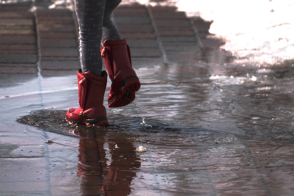 Gummistiefel bei Regen in Pfütze