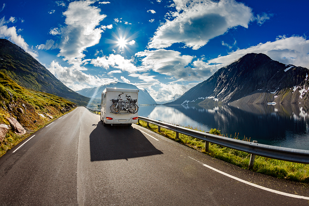 Wohnmobil auf Straße in schoener Landschaft