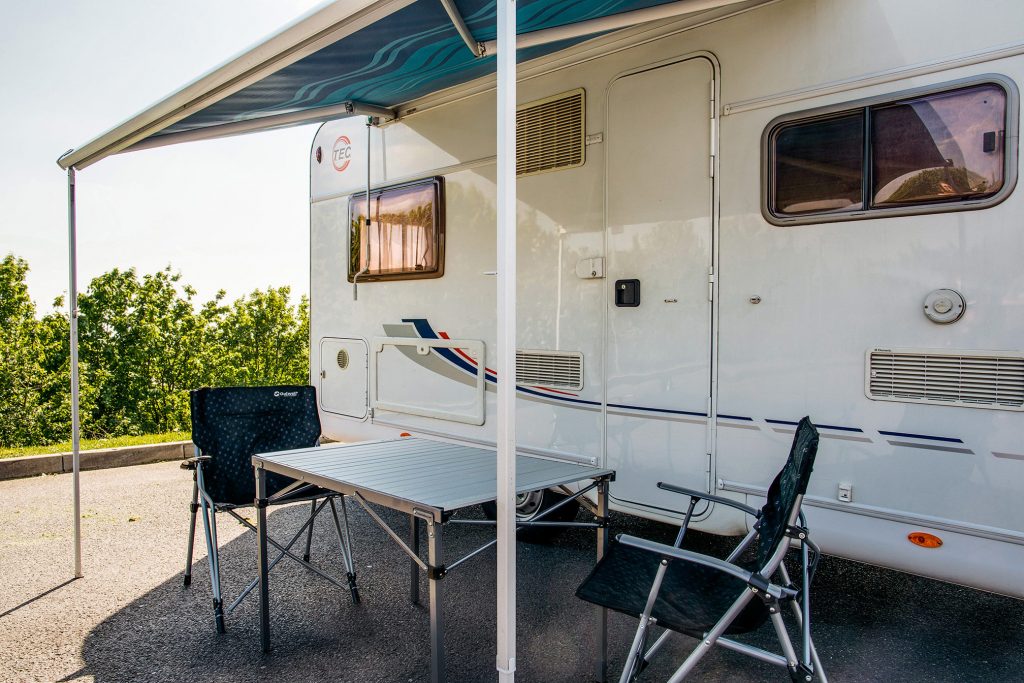 Wohnmobil mit Markise und Campingmoebeln