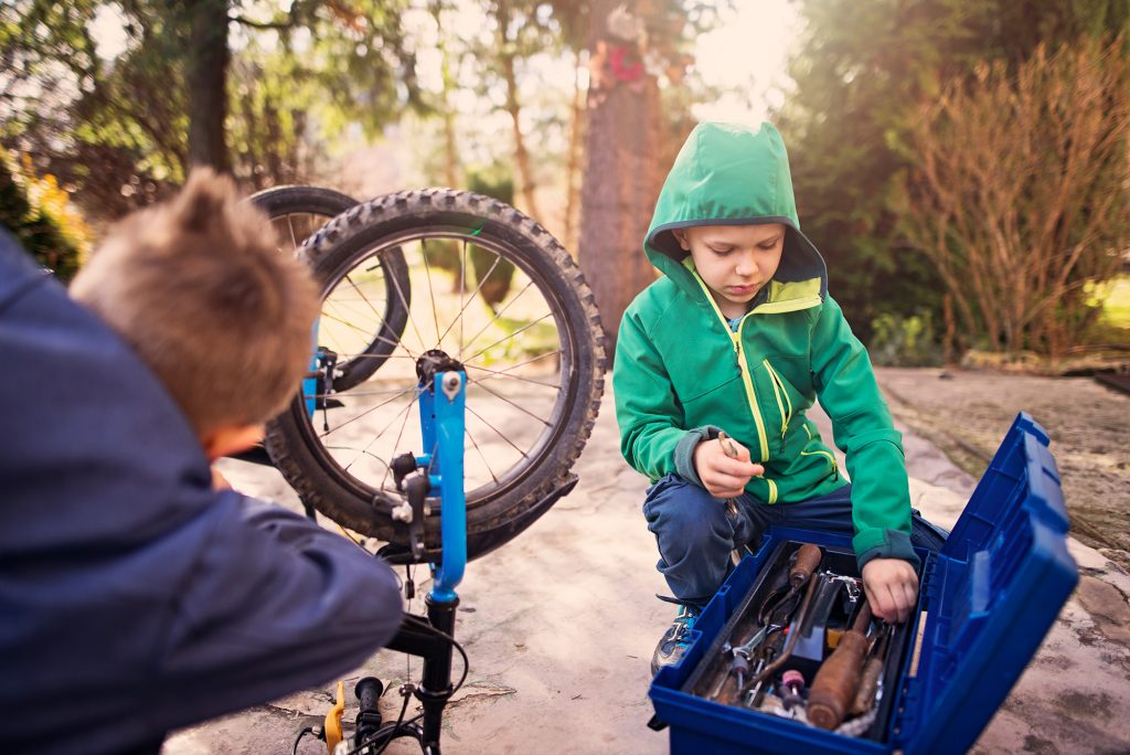 Zwei Jungen reparieren ein Fahrrad.