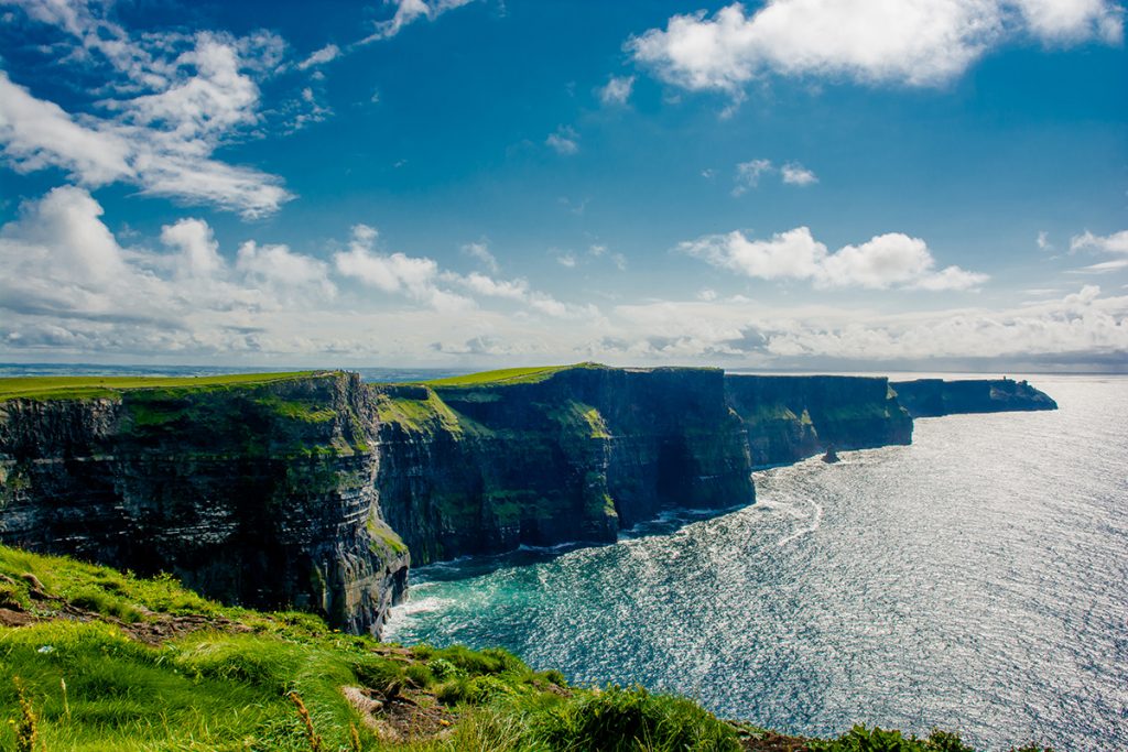 Grüne Fläche, Steilklippen und der Ozean in Irland.