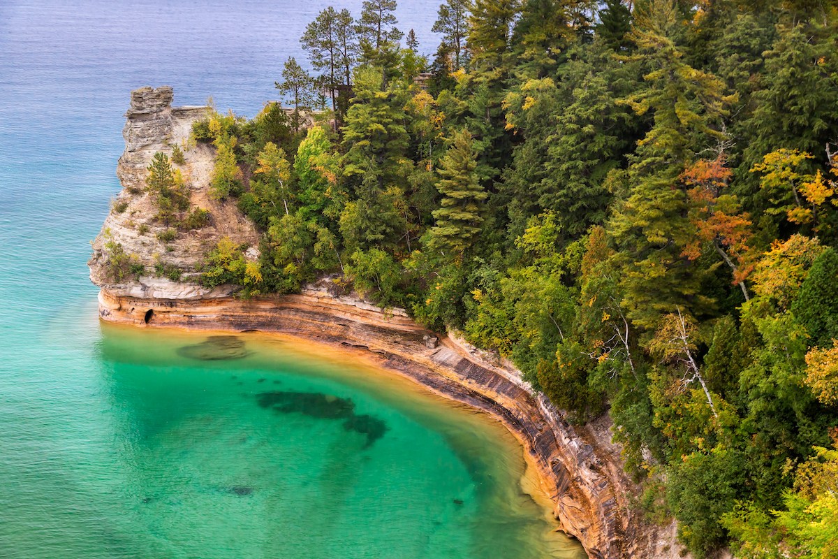 Blick von oben auf Miner's Caste, eine Felsformation, die in das türkise Wasser des Lake Superior hervorsticht.