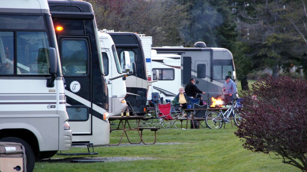 Eine Reihe Wohnmobile auf einem Campingplatz.