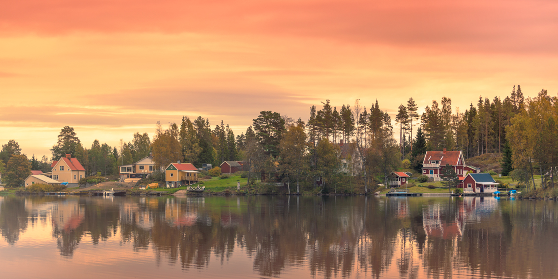 Bunte Häuser an einem See in der Region Dalarna, Schweden.