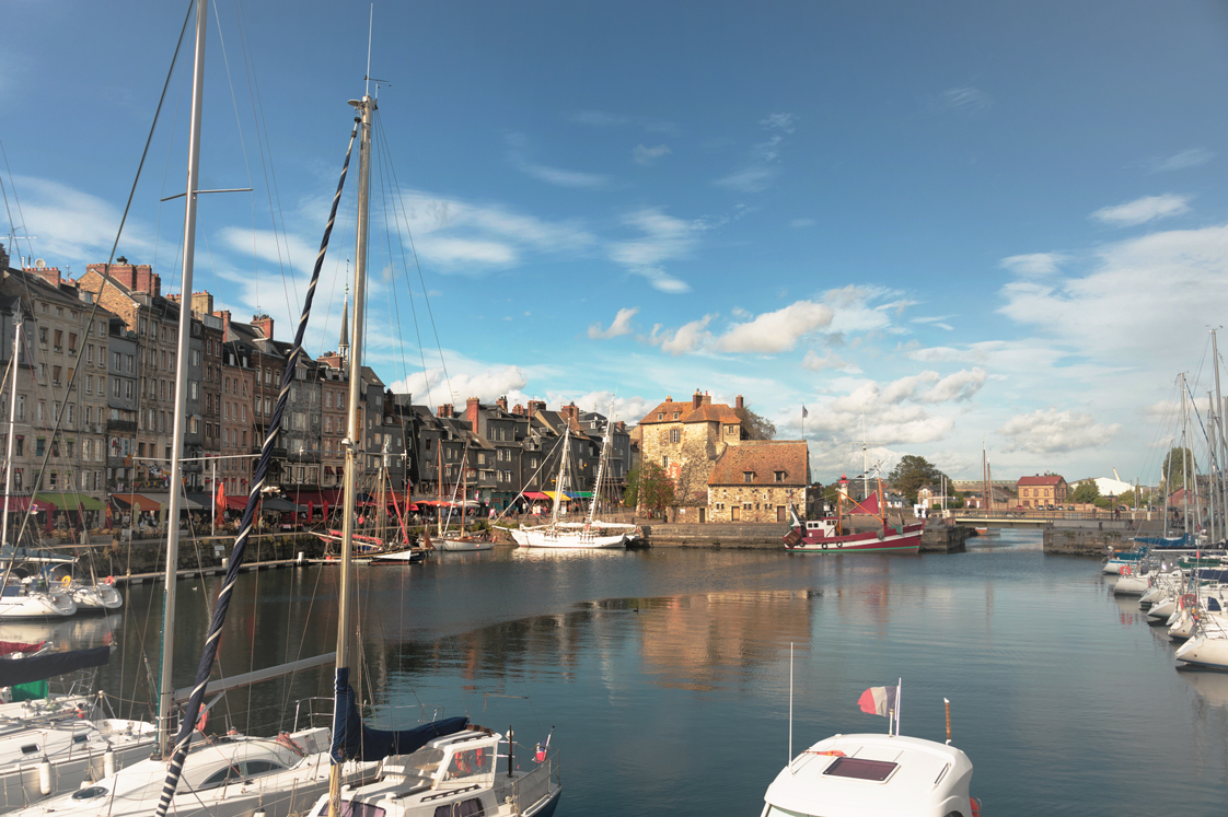 Häuser am und Boote auf dem Fluss in Honfleur, Frankreich.