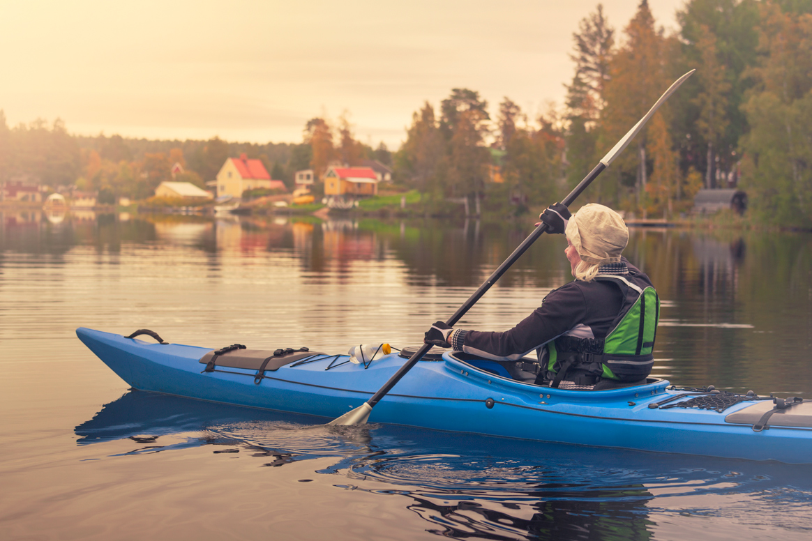 Eine Frau paddelt in einem Kanu auf einem See in Schweden.