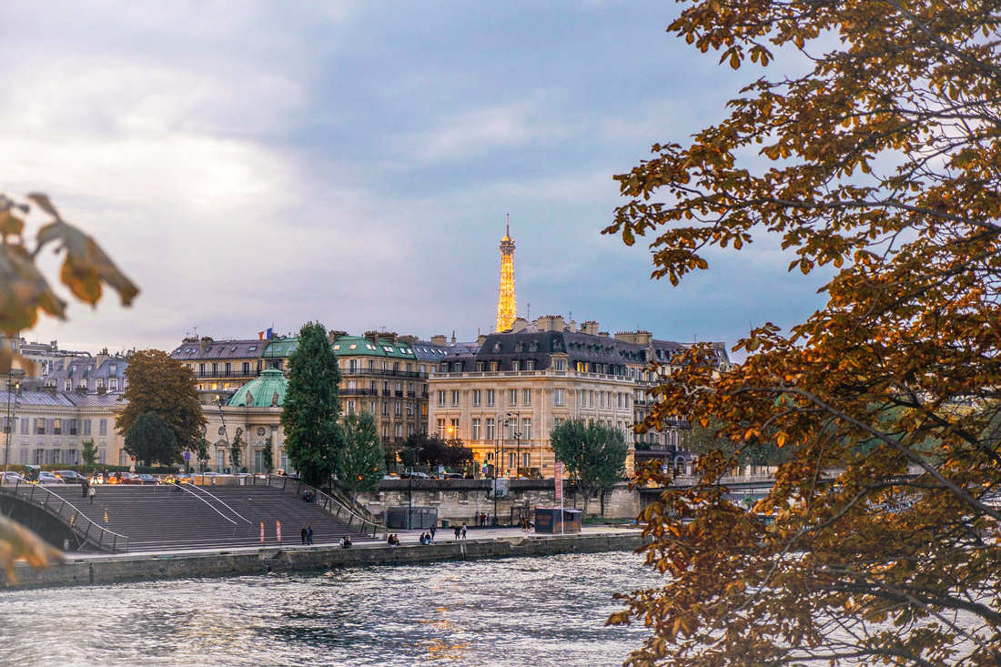 Die Seine, Gebäude und im Hintergrund die Spitze des Eifelturms in Paris, Frankreich.