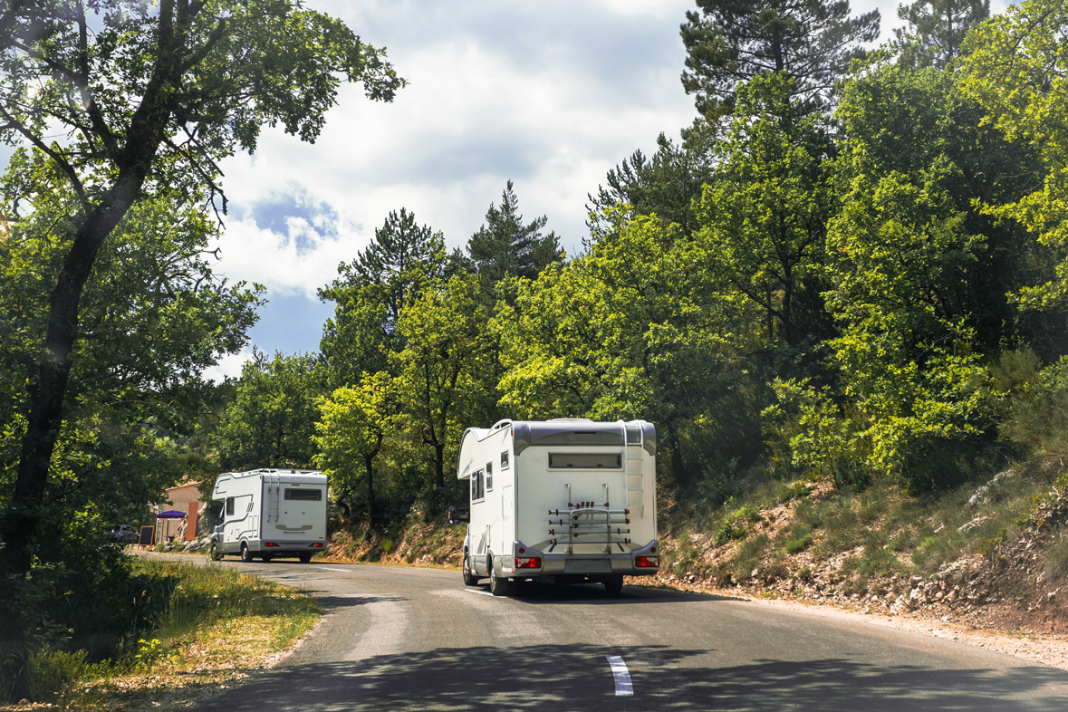 Zwei Wohnmobile auf einer Straße in Frankreich.