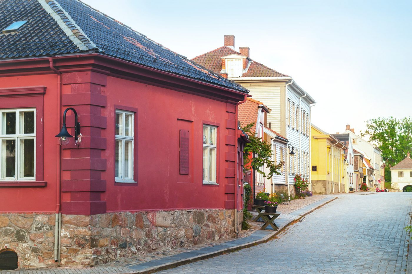 Die Erste Etappe deiner Tour mit dem Wohnmobil durch Norwegen, beginnt in Fredrikstad. Bunter Häuser in eine kleinen Kopfsteinpflaster-Straße in Fredrikstad.