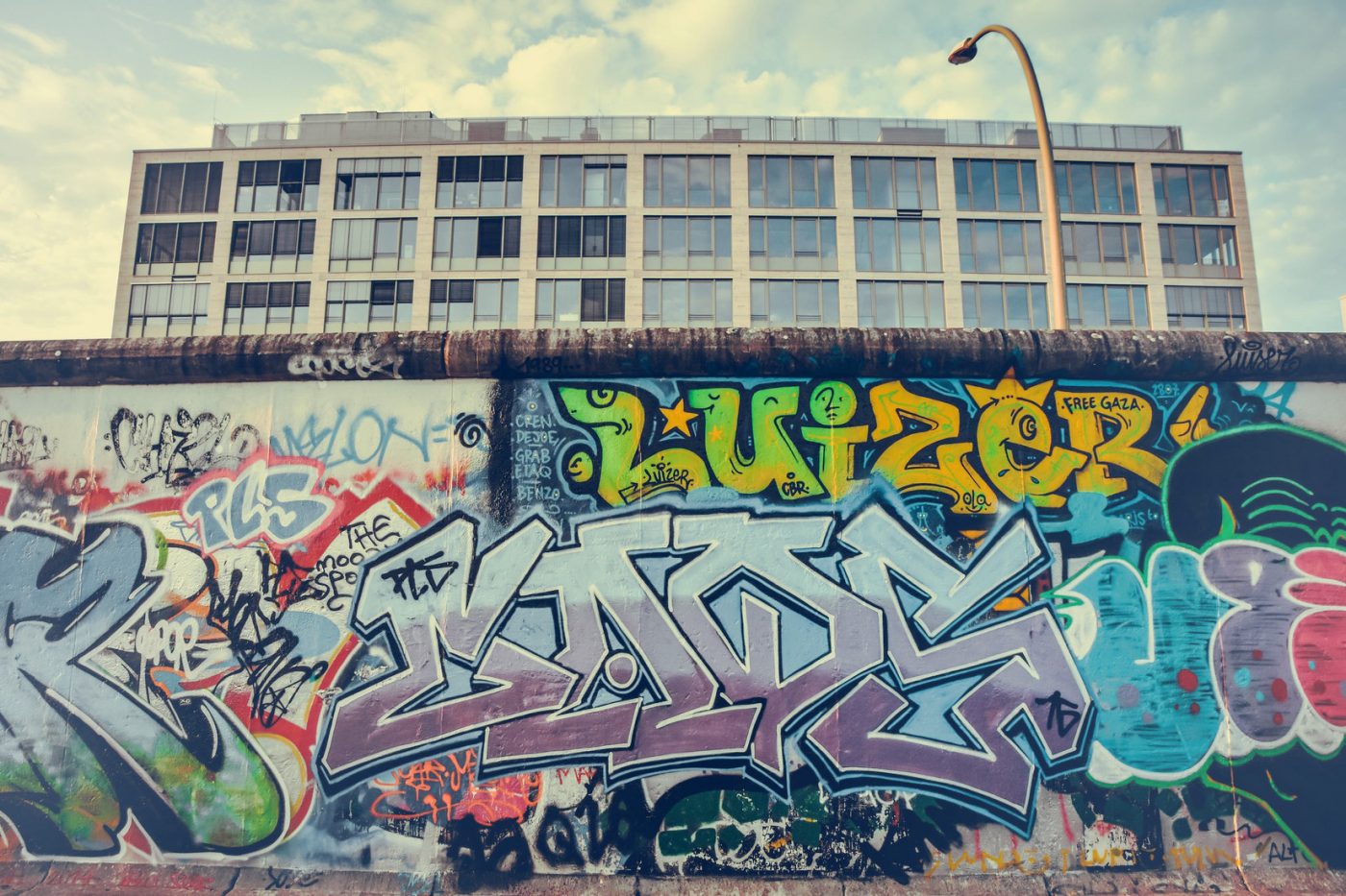 Ein Stück der Berliner Mauer, das mit Graffiti besprüht ist.