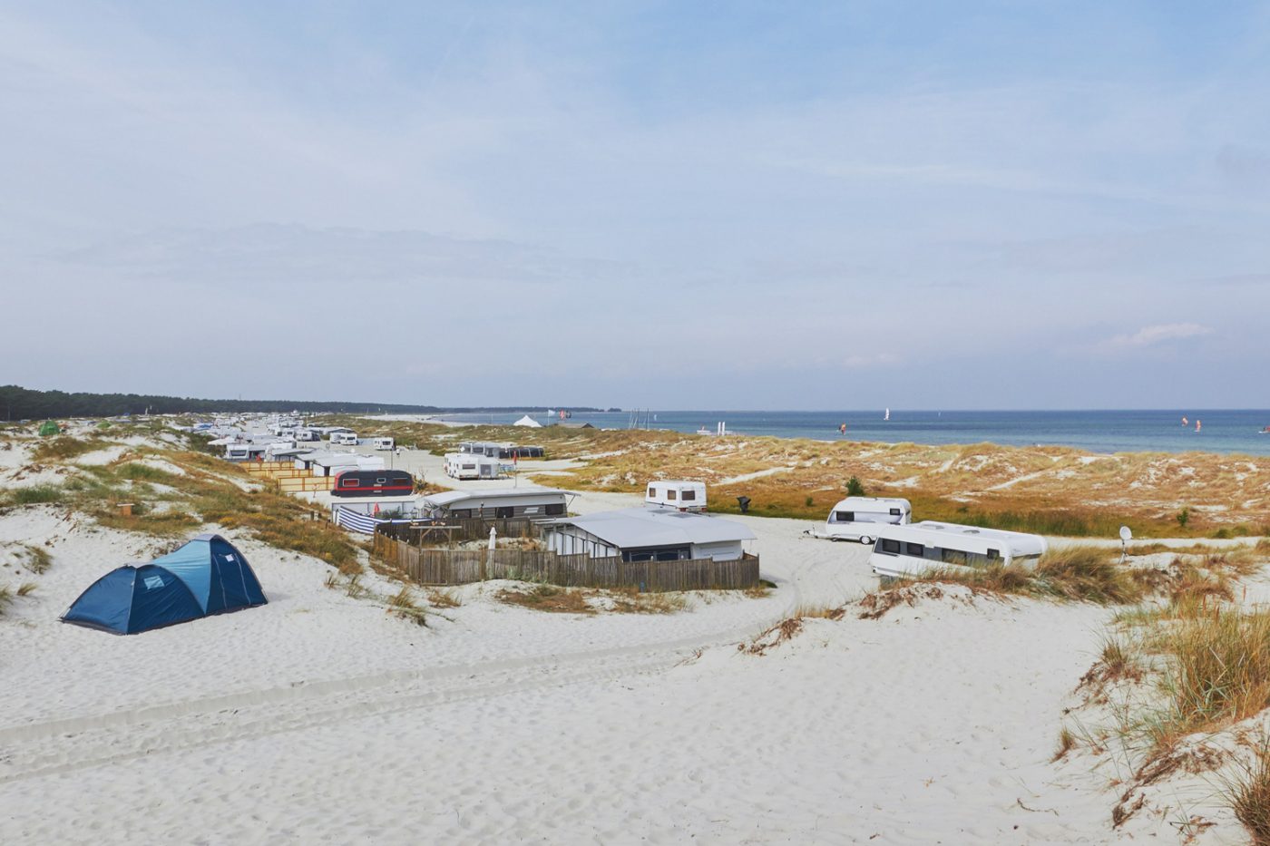 Mehrere Wohnmobile am Strand in den Dünen an der Ostsee.