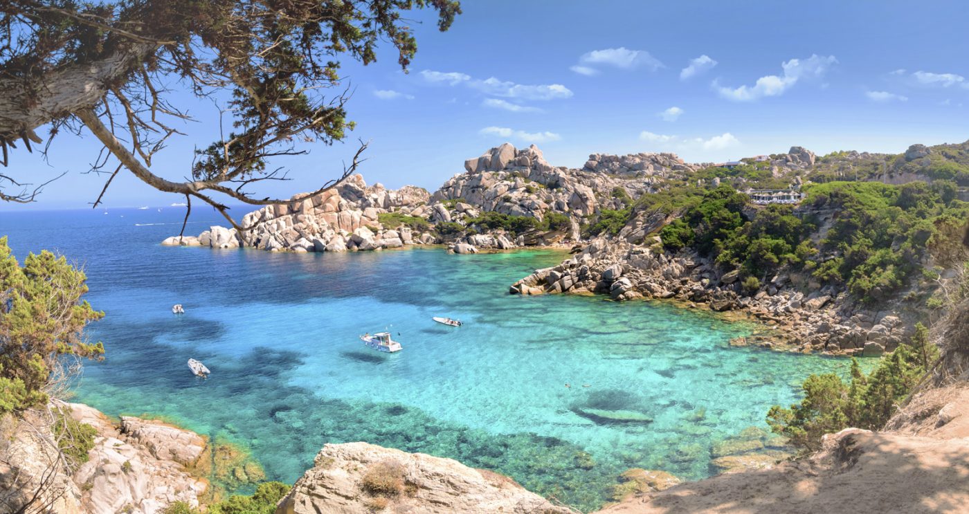 Eine Bucht mit türkisblauem Wasser und felsiger Küste auf Sardinien.