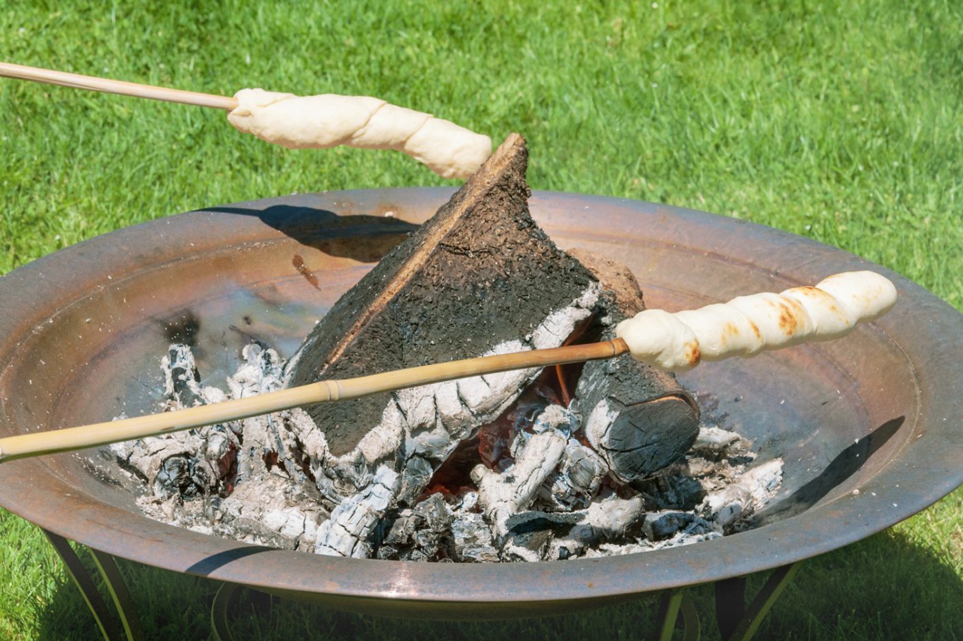 Stockbrot über einem Lagerfeuer.