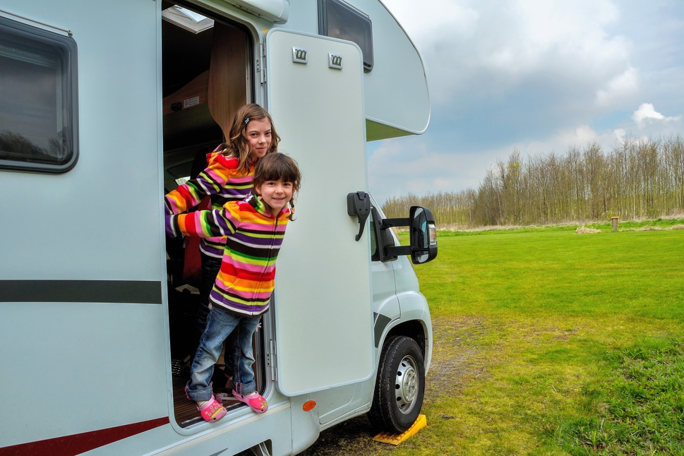 Zwei kinder schauen aus Wohnmobiltür heraus