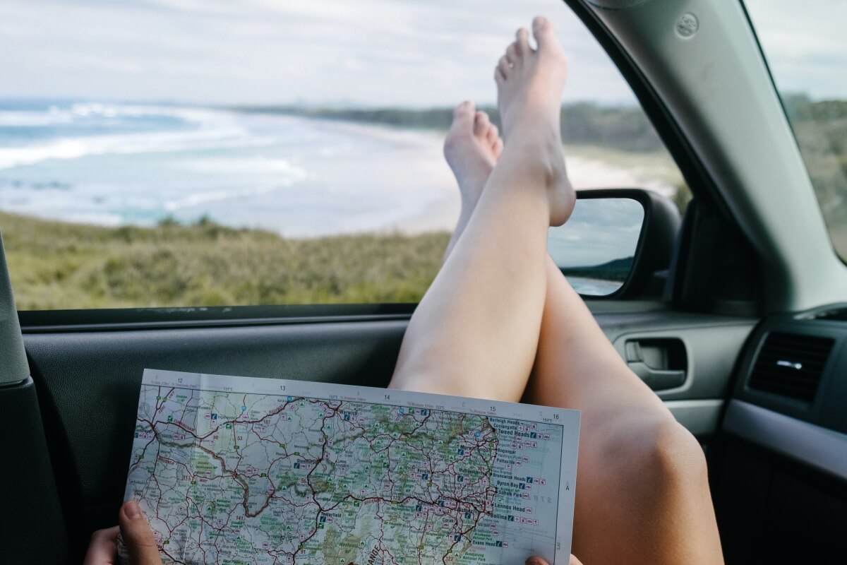 Landkarte lesen und Füße aus dem Autofenster