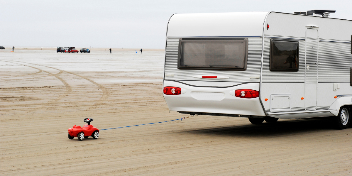 Wohnwagen und Bobbycar am Strand